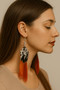 Side profile of a woman with long brown hair wearing a handmade5 Inch Long Pheasant Orange Tip feather earrings