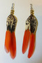 Pair of handmade 5 Inch Long Pheasant Orange Tip feather earrings laid flat on a white background,