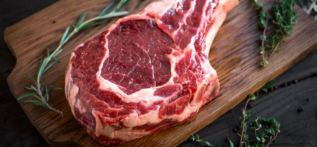 Fresh tomahawk steak on a wooden board