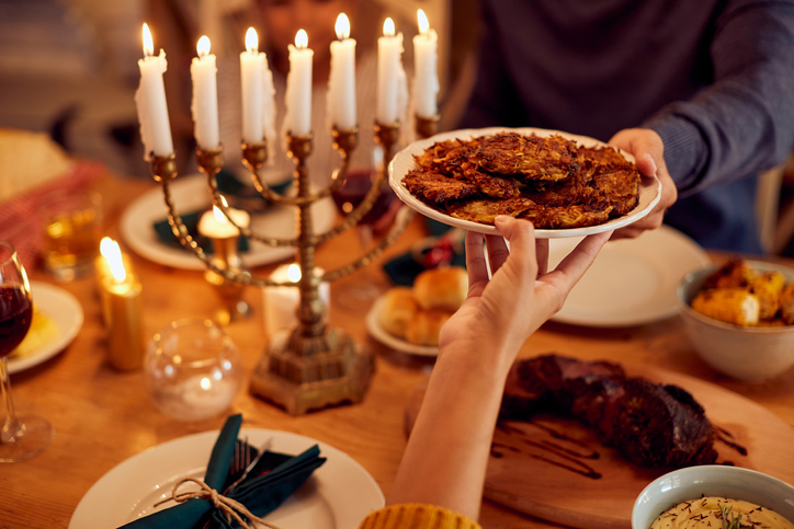 Latkas being passed over a dining table