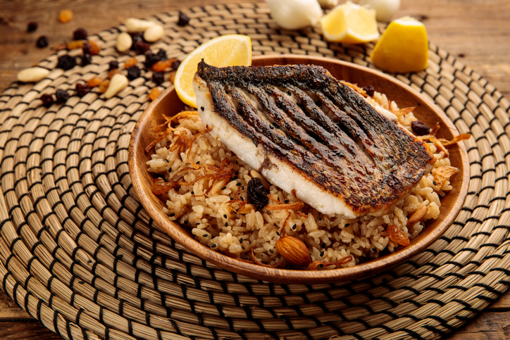 Sayadieh served in a dish on top of a wooden table placemat