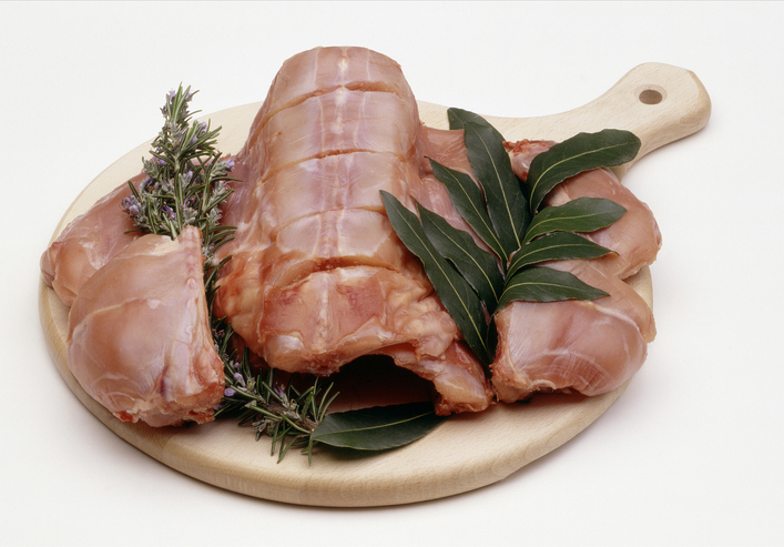 wood block with raw rabbit meat and garnish