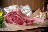 Black angus tomahawk steak on parchment paper