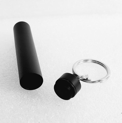 Black Travel Caddy opened laying on its side with cap and split rings in silver on white background.