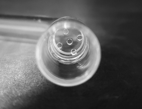 Closeup of 5 Hole Glass Screen in XL Aroma Tube chamber on dark background Closeup of 5 Hole Glass Screen in XL Aroma Tube chamber on dark background