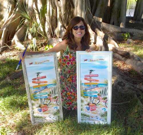 Artist Donna Elias showing off two of her sign posts; Captiva Island and Vero Beach, Florida.