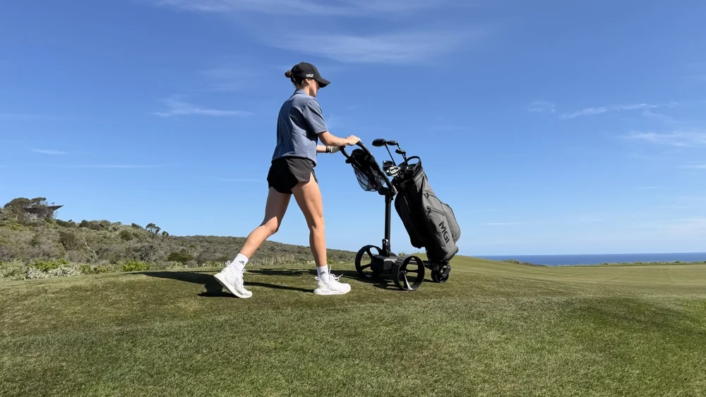 Golfer walking the fairway with the MGI E-Boost pushcart