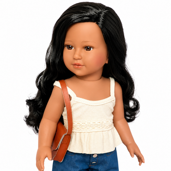 Amari™ Kennedy and Friends® 18-inch doll wearing an ivory peplum top, blue denim capri pants, white buckle sandals, and a brown crossbody bag. She has long black wavy hair, warm brown eyes, and a friendly expression, standing against a white background.
