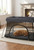 Aira's Nest™ dog retreat in dark gray with a golden retriever resting inside on the soft padded mat.