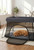 Aira's Nest™ dog retreat in dark gray with a golden retriever resting inside on the soft padded mat.