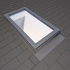 A VELUX deck-mounted skylight seamlessly installed on a shingle roof using the EDL flashing kit. The image emphasizes the clean lines and weathertight seal achieved with the flashing, demonstrating its ability to protect against water damage and enhance the skylight's performance