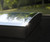 Detailed exterior shot of the CFU 090090 skylight installed on a roof, focusing on the quality of the curved glass and finish. Detailed exterior shot of the CFU 090090 skylight installed on a roof, focusing on the quality of the curved glass and finish.