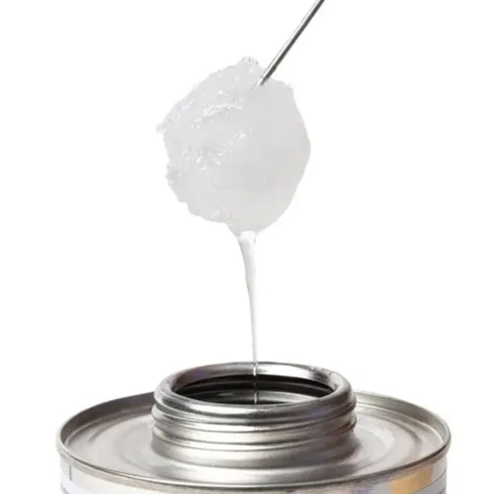 Close-up of clear PVC cement on applicator dauber showing thick liquid consistency used for sealing and bonding pond plumbing pipe fittings