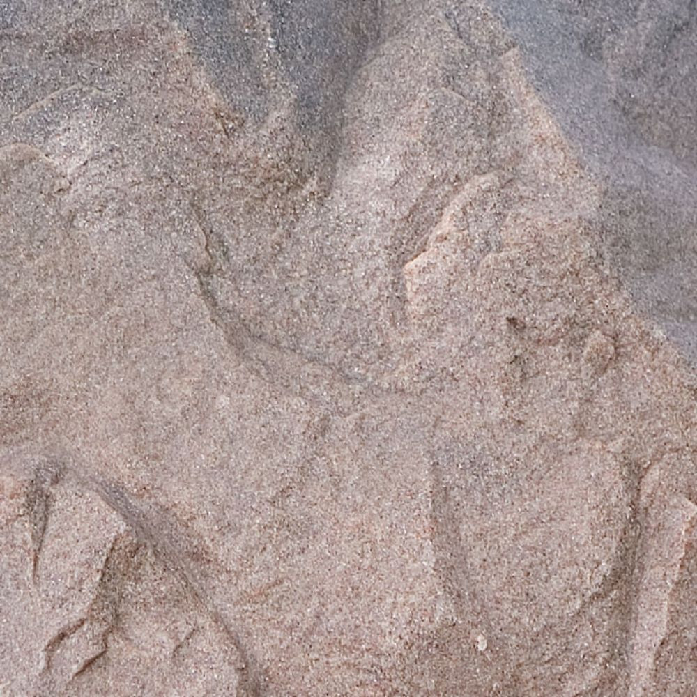 Close-up of DekoRRa’s Riverbed faux rock texture, showing an earthy blend of brown and gray tones for natural-looking outdoor coverage.