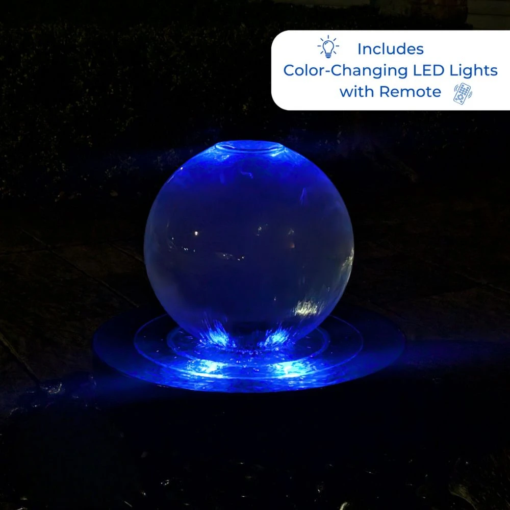 Blue Thumb crystal sphere fountain illuminated with blue LED lighting at night, showing water flowing evenly over the acrylic surface into the basin below.