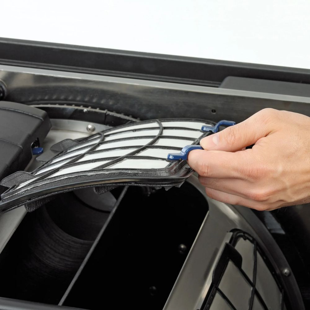 Hand removing rotary drum screen panel from Oase ProfiClear Premium XL gravity-fed pond filter for quick cleaning and easy maintenance access