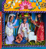 Close-up of colorful clay figures inside the Peruvian Fair Trade nativity, showing detailed faces and traditional Andean dress.