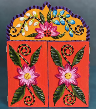 Exterior view of the closed Peruvian retablo, featuring bright floral designs hand-painted on the wooden doors. Exterior view of the closed Peruvian retablo, featuring bright floral designs hand-painted on the wooden doors.