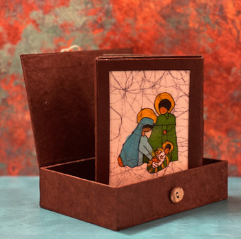 Hand-dyed batik nativity artwork from Nepal featuring bright panels of the Holy Family and Magi on natural lokta paper.