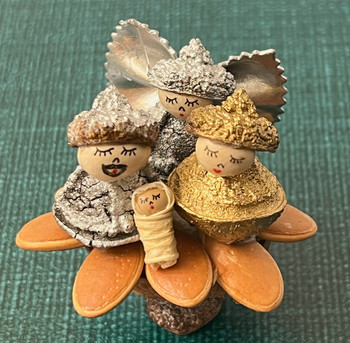 Handcrafted Ecuador nativity made from eucalyptus pods, pumpkin seeds, white beans, and a corn husk baby Jesus on a walnut shell base.