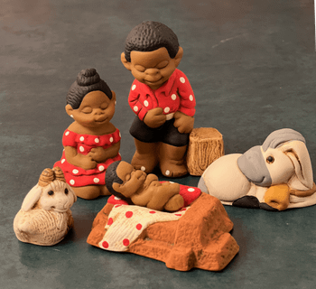 Peruvian ceramic nativity with Mary and Joseph in red with polka dots, baby in a manger and two animals