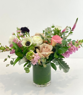 Adore Me This floral is a fun burst of subtlety with its pastel blush pinks, creamy white and hints of berry tones. This comes in a clear glass vase with leaf wrapped inside to conceal the stems and is available in many price ranges. Seattle flower delivery by Juniper Flowers
