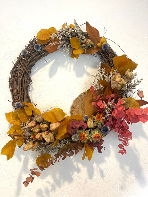 Autumn Dried Wreath 
This asymmetrical wreath is hand made by our designers on a grapevine base and includes elements of preserved beech and eucalyptus, german statice, dried mushroom, safflower, and thistle. This will keep for years to come with proper storage (we have found that a sealed garbage bag in a cool/dry environment works great for storage to keep the dust off) Diameter from widest points is 24".

Seattle flower delivery by Juniper Flowers

Due to changes in season, weather, and availability we reserve the right to make substitutions in flowers for your order. Our photos are a GUIDE to our designs.