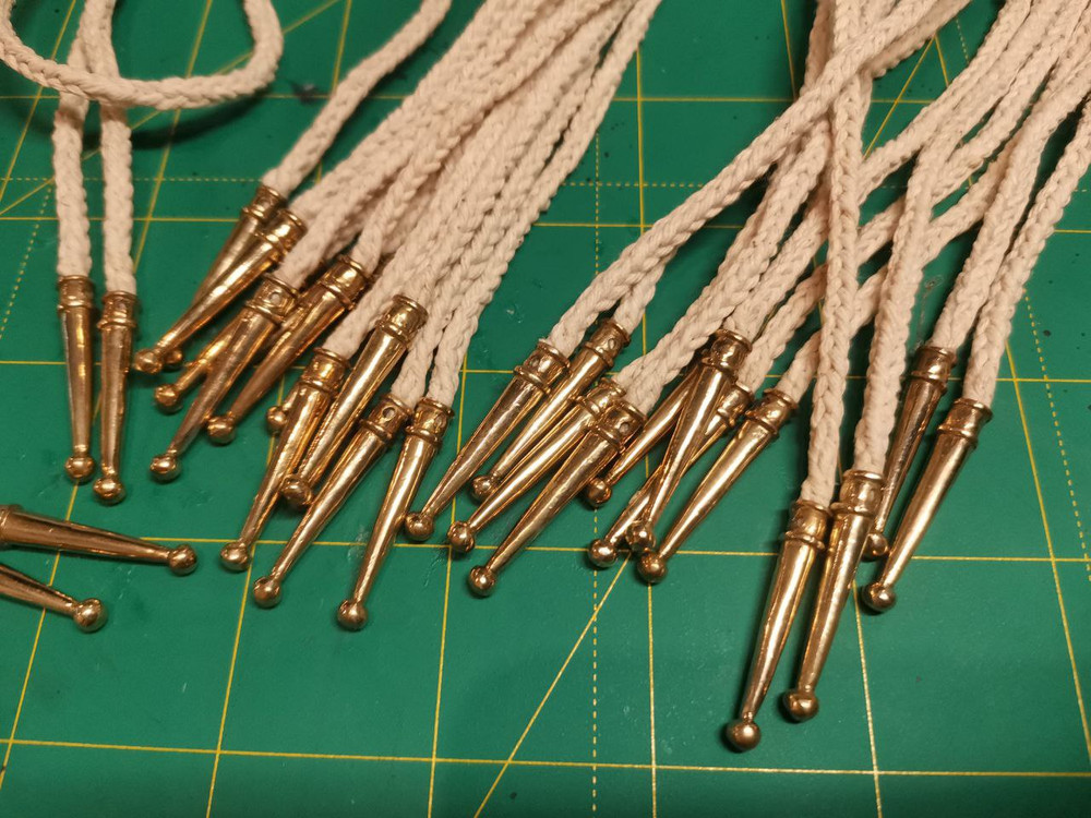 Hand-braided cord with brass tip