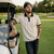 Man standing next to a golf cart on a golf course