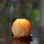 Pure Beeswax Sphere Candle, Lotus – lit lotus sphere glowing on a dark plate