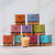 Beeswax Aromatherapy Beehive Glass Candle, Love – stacked colorful gift boxes with lit beehive glass candles