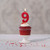 Beeswax Birthday Number Candle, 9 – lit on a frosted cupcake