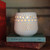 Lanai Hurricane Votive Candle Holder – lit pierced hurricane casting a glow on a shelf