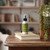 Aromatherapy Mist 4 oz, Meditation (Cedarwood & Balsam) – on stacked books in front of a bookshelf