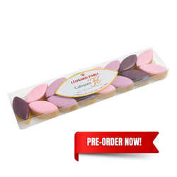 A strip of 15 small almond-flower flavored calissons in pastel shades, placed on a rectangular wafer base, each candy subtly tinted and shaped like a polished almond.