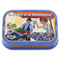 The image displays a tin of "Sardines à la Ratatouille," featuring a vividly colored and dynamic illustration. On the tin, there is a cheerful scene set in what appears to be a French marketplace. The central figures are a man and a woman engaging in a lively exchange over a table filled with sardines. The man, dressed in a farmer's hat and a blue vest, is tipping his hat and holding a basket brimming with fresh vegetables, suggesting ingredients typical of ratatouille such as peppers and eggplant, which are also noted in the description. The woman, who has curly red hair, a white top, and a playful expression, seems to be selecting or offering a sardine.

In the background, a vendor in a yellow hat is depicted at another market stall, with a cityscape and a palm tree visible, evoking the ambiance of Nice in the South of France. This setting aims to reflect the origins of ratatouille, a traditional Provencal dish.

The top of the tin reads the product's name, "SARDINES À LA RATATOUILLE," with additional details stating "Sardines with 'ratatouille' (peppers, eggplant)" to describe the contents. The net weight is listed as 4.05 oz (115g). The bottom of the tin has a label that reads "NICE" twice, further associating the product with the renowned French city. The overall design captures the essence of French market life, suggesting that the sardines are flavored with traditional ratatouille vegetables, and offering a taste of the French Riviera.
