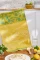 French jacquard cotton tea towel by Coucke featuring a detailed tarte au citron (lemon tart) illustration with bright citrus elements and warm golden tones.