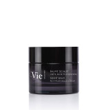 A dark jar of night balm labeled "Vie Collection" with text in French and English, showcasing a sleek, modern design.