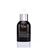 A dark glass serum bottle with a dropper cap, labeled "Sérum de Vie," resting on a textured stone surface.