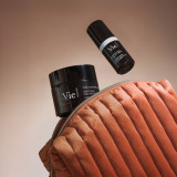 Vie Collection skincare products including Time Control cream and Chrono Eye cream in a quilted orange velvet cosmetic bag.
