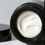 Mela Bright Dark Spot Brightening Cream jar with opened lid.