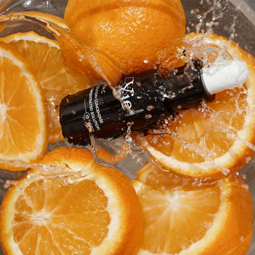 A black serum bottle is surrounded by fresh orange slices, splashing water creating a vibrant, refreshing scene. A black serum bottle is surrounded by fresh orange slices, splashing water creating a vibrant, refreshing scene.