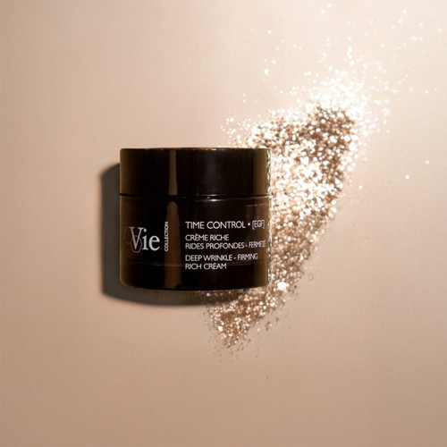 Vie Collection Time Control deep wrinkle firming rich cream jar with sparkling golden powder scattered beside it