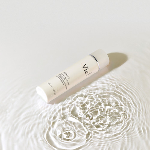 Mesoforce Gentle Micro-Exfoliating Lotion with PHA , laying on its side in a puddle of water.