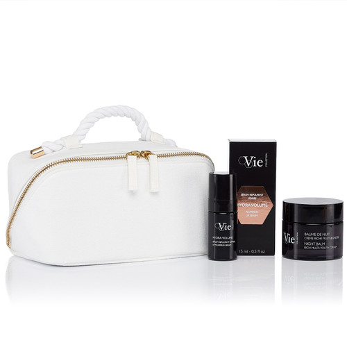 Night Balm Rich Multi-Youth Cream, Hydra Volume Lip Plumping Serum, next to in a white cosmetic pouch.