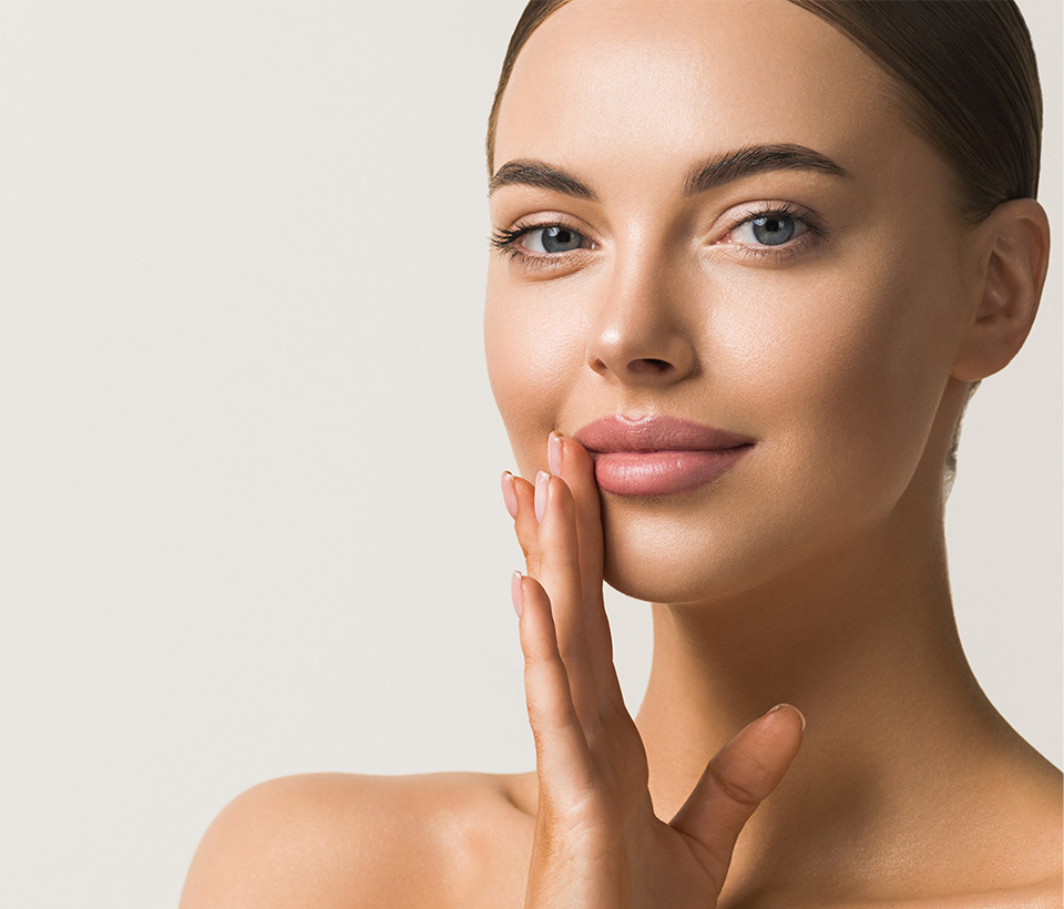 Woman with radiant skin showcasing Vie Collection's Hydra Volume lip plumping serum for naturally beautiful lips.