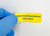 Lab technician applying FOR INVESTIGATIONAL USE ONLY Caution Label to storage container in biotech laboratory