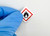 Lab technician applying Warning Flammable Label to container in laboratory environment
