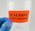 Lab technician applying CAUTION NON-STERILE label on solvent bottle