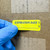 Warehouse manager applying C094 EXPIRATION DATE Caution Label to inventory container